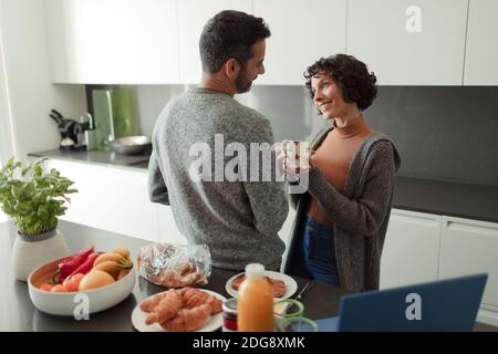 Ein glückliches Paar, das Frühstück und Kaffee in der morgendlichen Küche genießen kann Stockfoto