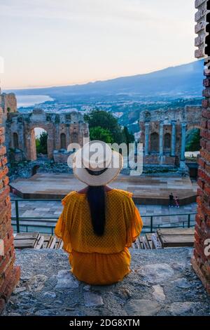 Taormina Sizilien, Paar beobachten Sonnenuntergang auf den Ruinen des antiken griechischen Theaters in Taormina, Sizilien. Paar mittleren Alters im Urlaub Sicilia Stockfoto