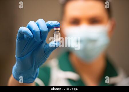 Eine Krankenschwester hält eine Ampulle des Pfizer/BioNTech-Impfstoffes am University Hospital in Coventry, am Anfang des größten Impfprogramms in der Geschichte Großbritanniens. Stockfoto