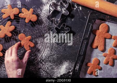 Eine Draufsicht auf eine Hand, die den Lebkuchenmann berührt Cookie Stockfoto