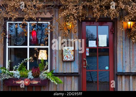 Altes Holzhaus mit Fenster, Lampe und Laterne, Pflanzen und Dekorationen Stockfoto