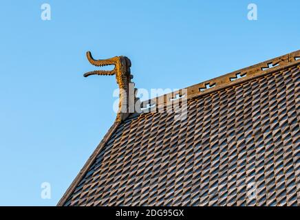 Detaillierte Holzschnitzereien von Drachenköpfen und Kreuzen auf einer mittelalterlichen hölzernen Stabkirche, die von den Wikingern erbaut wurde. Stockfoto