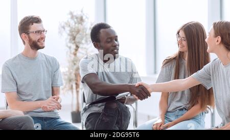 Junge Leute begrüßen sich auf dem Seminar Stockfoto