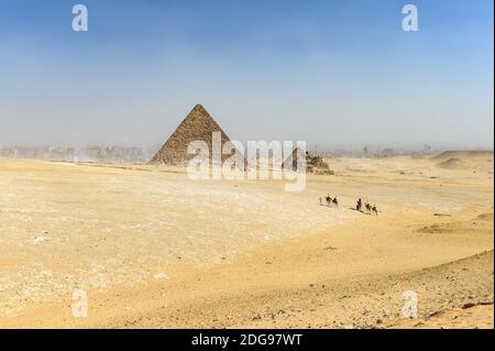 Panoramablick auf Gizeh Pyramid Komplex mit Kamelzug im Vordergrund, Gizeh, Kairo, Ägypten Stockfoto