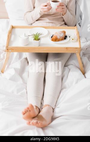 Beschnittene Ansicht der Frau mit Vitiligo halten Tasse in der Nähe des Frühstücks Auf dem Fach Stockfoto