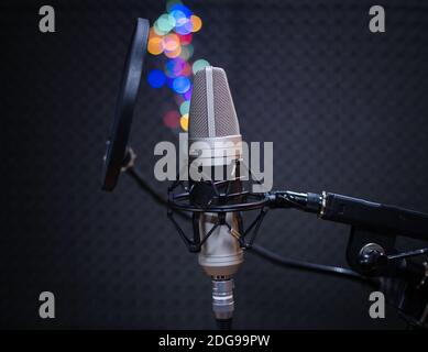 Sprachmikrofon mit Schockhalterung und POP-Filter auf professionellem Stativ in Audio-Aufnahmestudio. Konzept der Verwendung von Aufnahmemmikrofon für Stockfoto