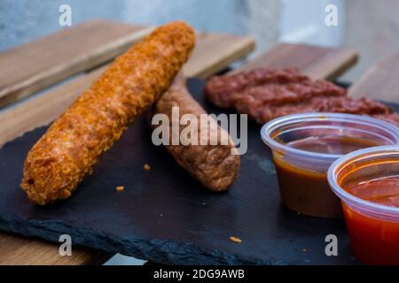 Verschiedene gebratenes Fleisch. Verschiedene Arten von Schweinefleisch Steak, Hühnerfilet und Rinderwurst mit einigen Saucen auf dunklem Holzhintergrund. Gegrillt und Barb Stockfoto