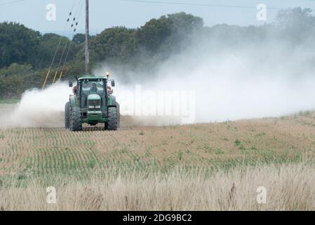 Ein John Deere Traktor verteilt Kalkdünger auf Ackerland in Hayling Island, Hampshire, Großbritannien Stockfoto