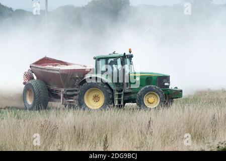 Ein John Deere Traktor verteilt Kalkdünger auf Ackerland in Hayling Island, Hampshire, Großbritannien Stockfoto