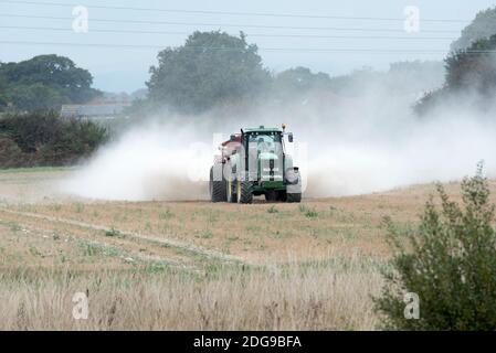 Ein John Deere Traktor verteilt Kalkdünger auf Ackerland in Hayling Island, Hampshire, Großbritannien Stockfoto