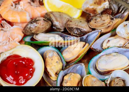 Gegrillte Muscheln mit grünen Lippmuscheln und Shrimp-Zitrone und Tomatensauce Bereit zum Essen Stockfoto