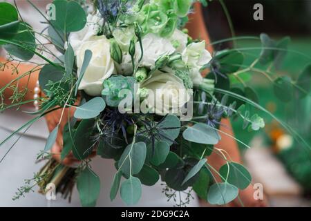 Ein Strauß der Braut aus den lebendigen Blumen der Rose, hält die Braut in der Hand Stockfoto