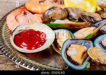 Meeresfrüchte bereit zu essen. Meeresfrüchteauswahl an gekochten Muscheln und Shrimp Lemon Stockfoto