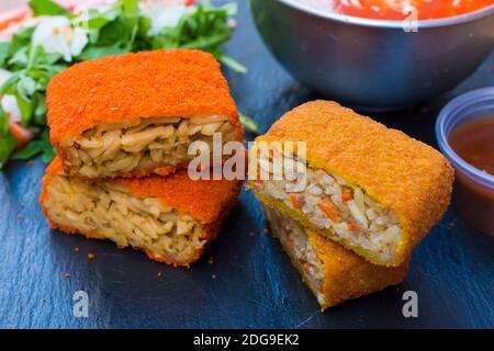 Klassische, italienische arancini. Frittierte Reisbällchen mit Hackfleisch und etwas Gemüse im Inneren. Leckere knusprige Speisen mit Erdnusssauce und Tomatensuppe Stockfoto