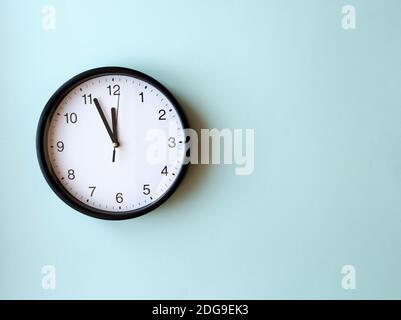 Runde Wanduhr auf blauer Oberfläche mit 12 Uhr, Layout, Draufsicht, Platz für Text Stockfoto