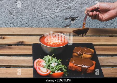 Klassische, italienische arancini. Frittierte Reisbällchen mit Hackfleisch und etwas Gemüse im Inneren. Leckere knusprige Speisen mit Erdnusssauce und Tomatensuppe Stockfoto