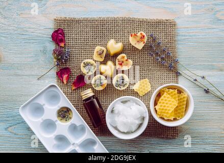 Herstellung von Mini Wachs schmelzen für Aroma Lampe Diffusor zu Hause Konzept. Werkzeuge Zutaten auf dem Tisch ungebleichtes Bienenwachs, festes Kokosöl, ätherisches Öl. Stockfoto