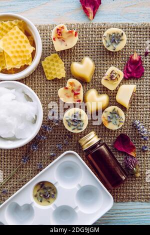 Herstellung von Mini Wachs schmelzen für Aroma Lampe Diffusor zu Hause Konzept. Werkzeuge Zutaten auf dem Tisch ungebleichtes Bienenwachs, festes Kokosöl, ätherisches Öl. Stockfoto