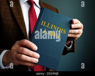 State Illinois Gesetz Konzept. Ein Mann in einem Anzug hält ein Buch. Stockfoto