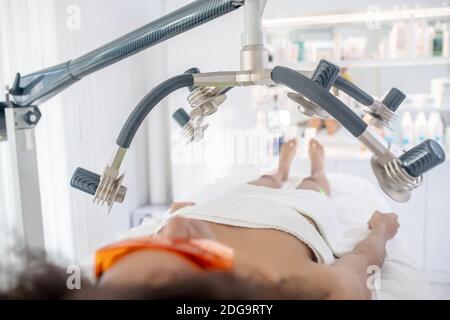 Frau liegt auf Körper Konturierung Sitzung Stockfoto