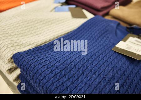 Herren Strickpullover in Pastellfarben auf Ladentisch gestapelt Stockfoto