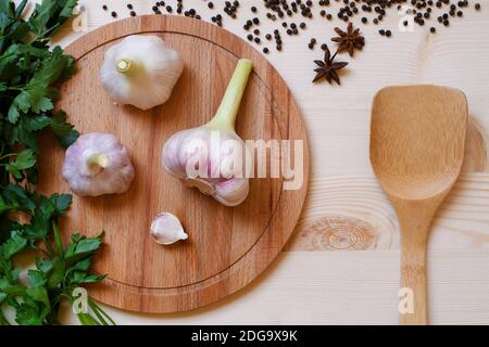 Essen Hintergrund mit frischen Bioprodukten Grüns, Gewürzen und Knoblauch auf Holzplatte mit Bambus Löffel Stockfoto
