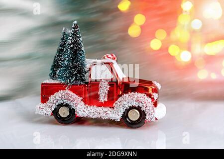 Weihnachtsschmuck für den Weihnachtsbaum. Spielzeug roten Glas Auto trägt einen Weihnachtsbaum. Girlande-Lichter. Speicherplatz kopieren. Stockfoto