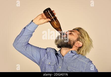 Betrunken Hipster männlichen Handwerk abgefülltes Bier. Glücklicher Mann halten volle Glasflasche in der Hand. Männlich hält Flasche Bier. Hipster Rest in Pub. Sportliebhaber aufmuntern. Reifer Mann hält eine Glasflasche Bier. Stockfoto