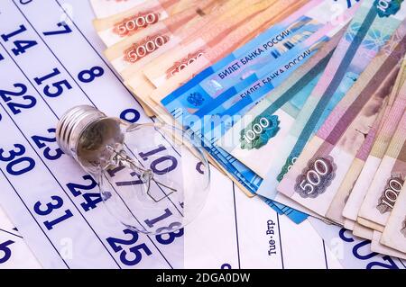 Kalender und russisches Geld, Glühbirne und Kalender, Lampe und Geld, russisches Geld Stockfoto