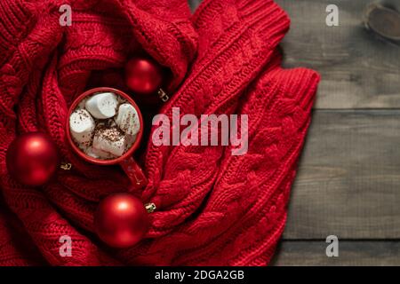 Tasse heiße Schokolade mit Marshmallow auf dem warmen Strickschal. Weihnachtsschmuck. Selektiver Fokus. Geringe Schärfentiefe. Stockfoto