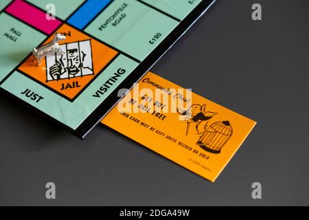 Eine Monopoly Community Chest Get Out of Jail Free-Karte Neben dem Hundespiel auf dem in Jail/Just Besucherplatz Stockfoto