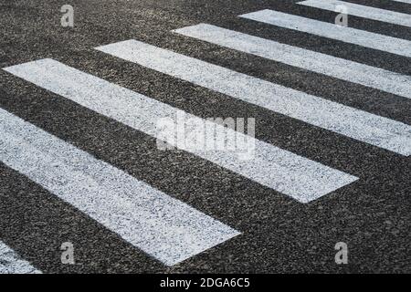 Ein leerer Fußgängerüberweg auf einer neuen Straße. Der Straßendienst zeichnete die Markierungen. Horizontales Foto. Stockfoto