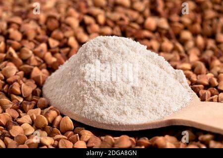Löffel Buchweizenmehl auf rohen gerösteten Buchweizen. Stockfoto