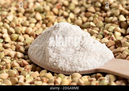 Löffel Buchweizenmehl auf rohen grünen Buchweizen. Stockfoto