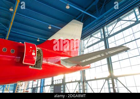 Mechanische Systeme für Flugbetrieb prüfen. Passagierflugzeuge im Hangar. Rückansicht des Flugzeugs Stockfoto