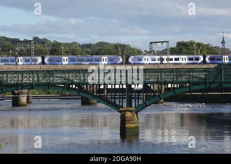 Ayr Ayrshire, Schottland, Großbritannien der Scotrail-Personenzug überquert den Fluss Ayr. Im Vordergrund befindet sich die Stahlfußbrücke, die als Turners Bridge bekannt ist Stockfoto