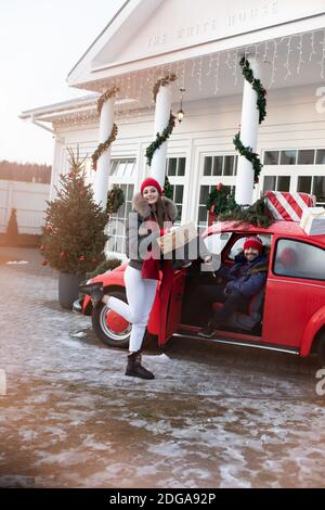 Junges Paar kauft Weihnachtsgeschenke für ihre Familie und nehmen Sie nach Hause in einem roten Auto Stockfoto