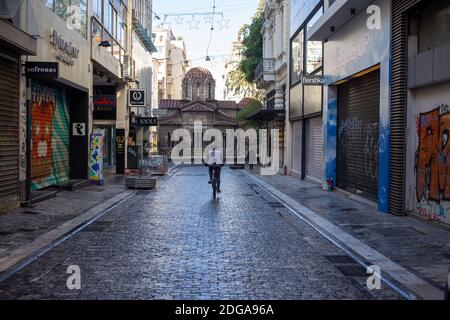 Athen Stadtzentrum, Griechenland. Dezember 2020. Biker auf leerer Ermou Straße, Wintertag. Geschäfte geschlossen, COVID 19 Pandemiesperre Stockfoto