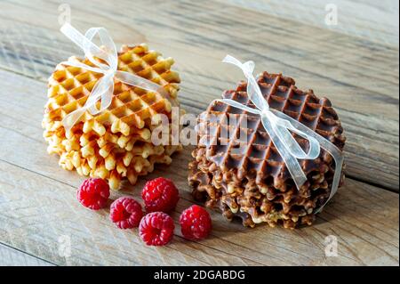 Zum Frühstück gab es frische, knackige belgische Waffeln mit reifen Himbeeren Ein rustikaler Holztisch Stockfoto