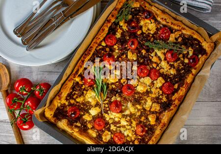 mediterraner herzhafter Tortenkuchen mit Hackfleisch aus Schweinefleisch und Rindfleisch, Feta-Käse, Tomaten und Kräutern. Im Ofen gebacken mit Blätterteig. Overhead-Ansicht Stockfoto