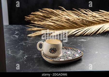 Gold bemalte Keramik türkischen Kaffeetasse auf dem Tisch Stockfoto