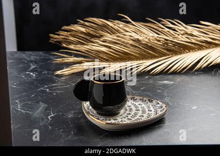 Gold bemalte Keramik türkischen Kaffeetasse auf dem Tisch Stockfoto