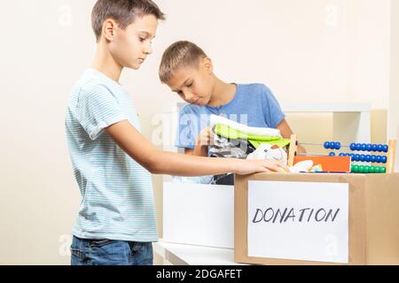 Kinder Freiwillige Sortieren Spielzeug, Kleidung, Bücher, Spenden Waren in Spenden Wohltätigkeitskisten Stockfoto