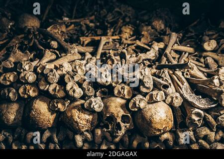 Ein Haufen verwitterter, alter Haufen menschlicher Knochen Und Schädelstücke auf einem Boden Stockfoto