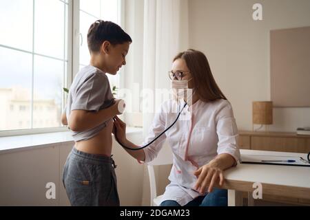 Netter Junge mit Vergnügen Besuch Kinderarzt, geplante Überprüfung der Gesundheit Babys, Termin mit dem Hausarzt, gesunde Lebensweise Stockfoto