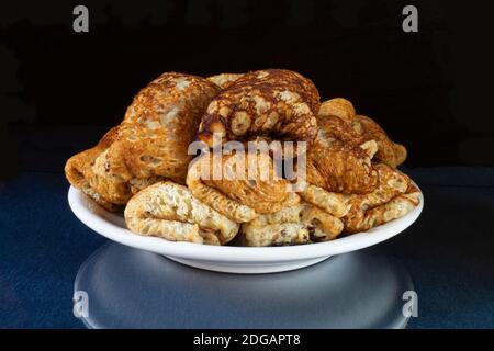 Die Pfannkuchen mit Füllung in weißen Teller auf Tisch mit Reflexion. Produkte der Fütterung auf schwarzem Hintergrund Stockfoto