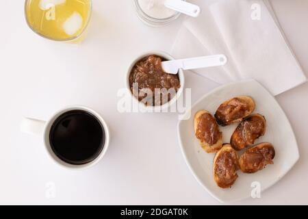 Hausgemachtes Brot Toast mit einem leckeren hausgemachten Apfel und Zwiebel Chutney, mit Zimt auf einem hellen weißen Brett. Perfekte Marmelade zum Frühstück. Stockfoto