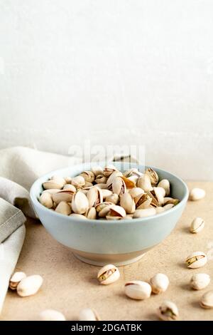 Pistazien. Pistazien in einer Keramikplatte und eine Serviette auf dem Tisch Stockfoto