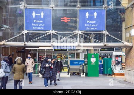 Menschen mit schützenden Gesichtsmasken verlassen Liverpool Street Station, London. Stockfoto