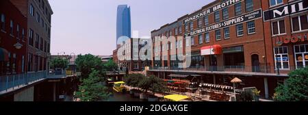 Bricktown Mercantile Gebäude entlang des Bricktown Canal mit Devon Tower im Hintergrund, Bricktown, Oklahoma City, Oklahoma, USA Stockfoto